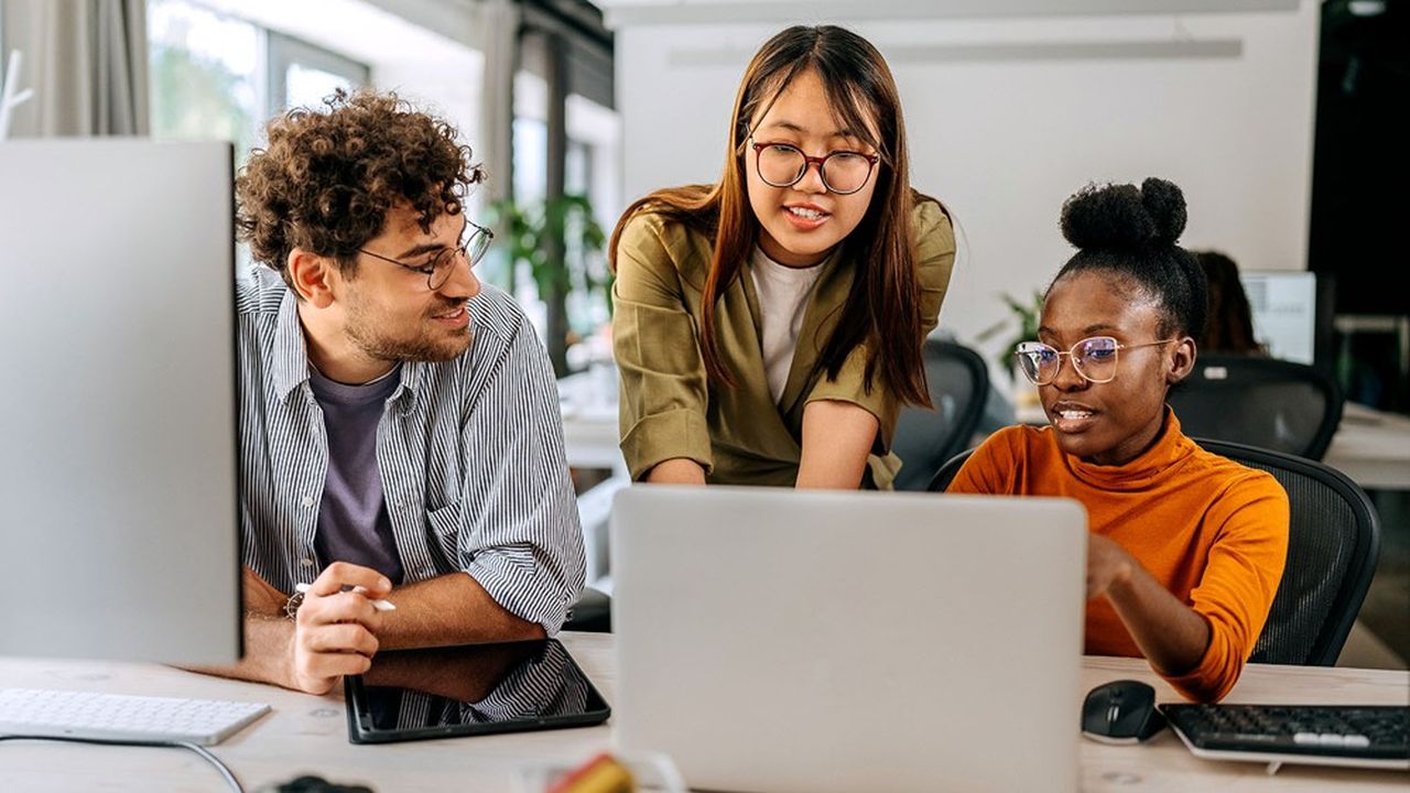 Three young colleagues discussing work at modern office